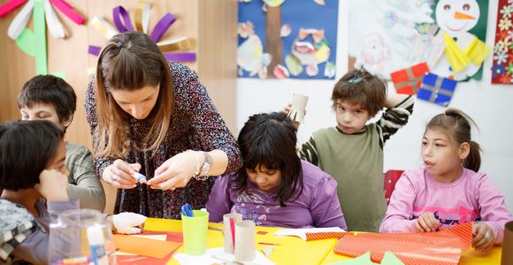 Female teacher with multiple students in classroom