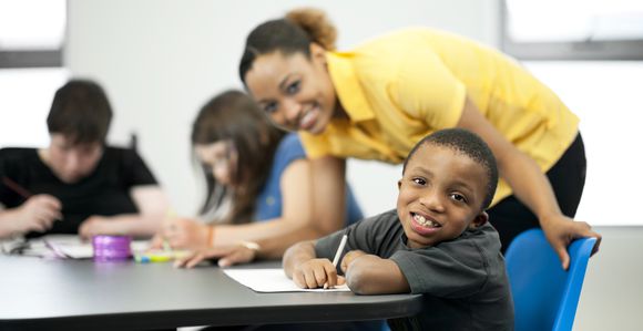 Female teacher with male student in classroom