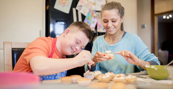 Staff making cupcakes with student